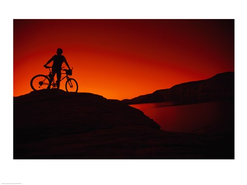 Framed red Silhouette of a man standing with his mountain bike, Lake Powell Print