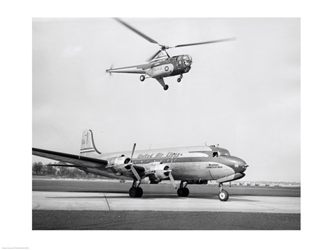 Framed Low angle view of a helicopter in flight and an airplane at an airport, Sikorsky Helicopter, Douglas DC-4 Print