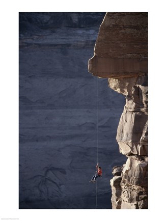 Framed Man hanging from a rope on the edge of a cliff Print