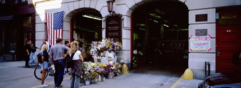 Framed Rear view of three people standing in front of a memorial at a fire station, New York City, New York State, USA Print