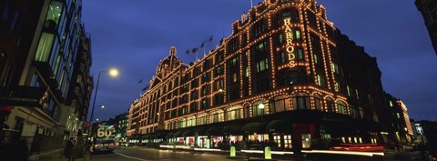 Framed Low angle view of buildings lit up at night, Harrods, London, England Print