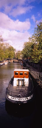 Framed Tourboat docked in a channel, Amsterdam, Netherlands Print