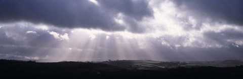 Framed Sunbeams radiating through dark clouds over rolling hills, Dartmoor, Devon, England Print