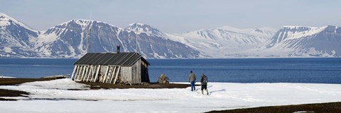Framed Two hikers standing on the beach near a hunting cabin, Bellsund, Spitsbergen, Svalbard Islands, Norway Print