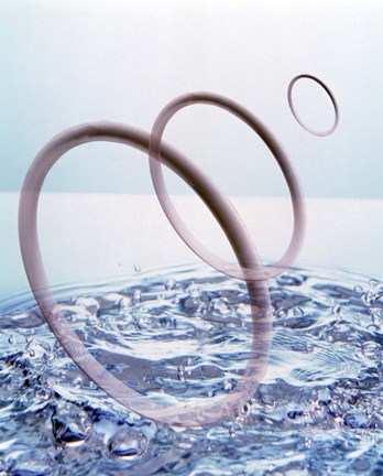 Framed Three opaque white circles floating away from churning water Print