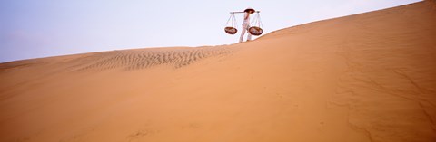 Framed Low angle view of a woman carrying panniers, Mui Ne, Vietnam Print