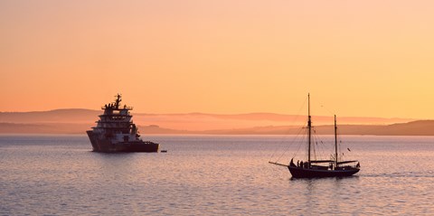 Framed Tugboat and a tall ship in the Baie de Douarnenez at sunrise, Finistere, Brittany, France Print