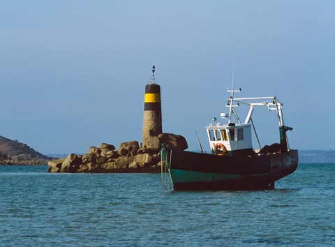 Framed Fishing trawler in front of a lighthouse at Port Saint-Sauveur, Ile Grande, Cotes-d'Armor, Brittany, France Print