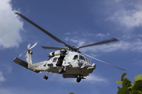 Framed Crew Chief looks out the side door of a helicopter in flight Print