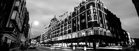 Framed Low angle view of buildings lit up at night, Harrods, London, England BW Print