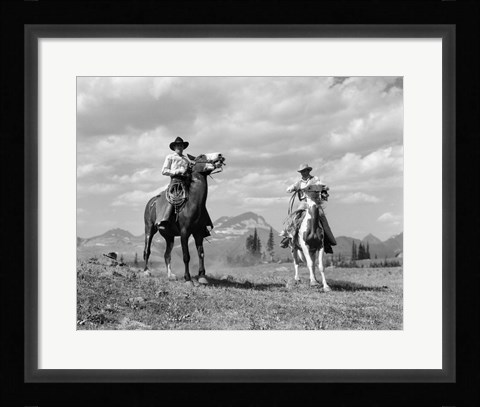 Framed Pair Of Cowboys On Horseback At Glacier Fifty Mountain Camp Print