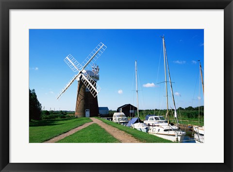 Framed Boat moored near a traditional windmill, River Ant, Norfolk Broads, Norfolk, England Print