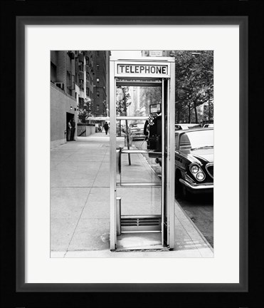 Framed Car parked at the side of a road near a telephone booth Print