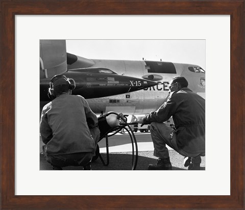 Framed Rear view of two men crouching near fighter planes, X-15 Rocket Research Airplane, B-52 Mothership Print