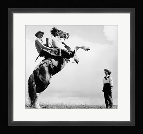 Framed Low angle view of a cowboy riding a bucking horse Print