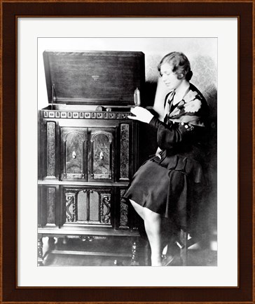 Framed Young woman sitting beside an RCA Radio-Phonograph and Home Recorder Print