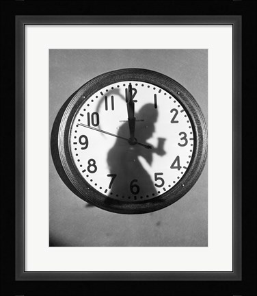 Framed Close-up of the shadow of a person carrying a scythe on a clock Print