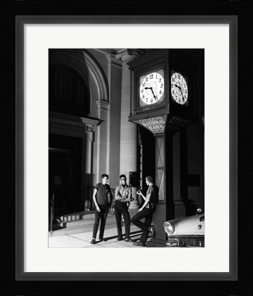 Framed Young men standing below clock at night Print
