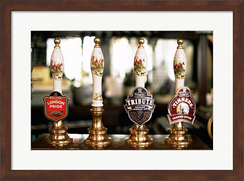 Framed Close-up of beer tap handles in a bar, London, England Print