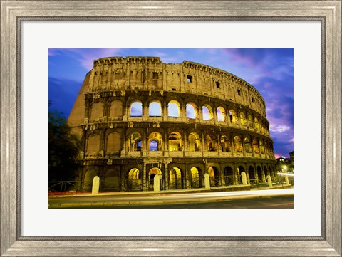 Framed Low angle view of the old ruins of an amphitheater lit up at dusk, Colosseum, Rome, Italy Print