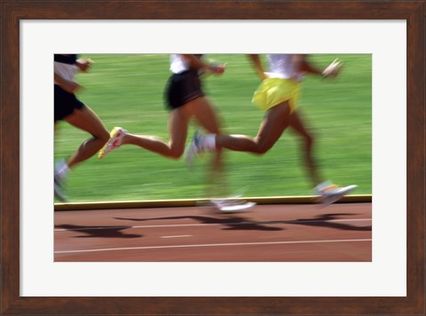 Framed Low section view of male athletes running on a running track Print