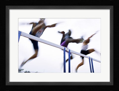 Framed Low angle view of three men jumping over a hurdle Print