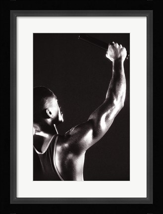 Framed Male runner holding up a relay baton Print