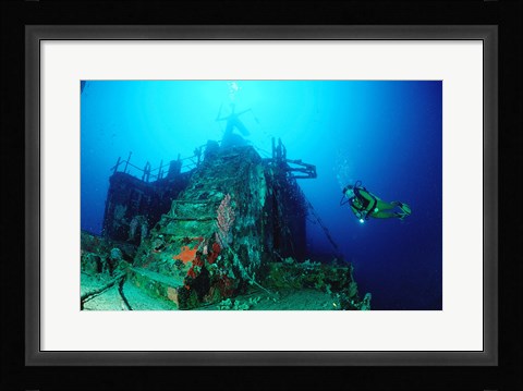 Framed Scuba diver watching a shipwreck underwater Print