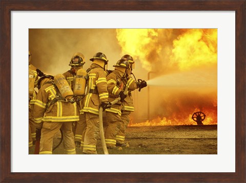 Framed Rear view of a group of firefighters extinguishing a fire Print