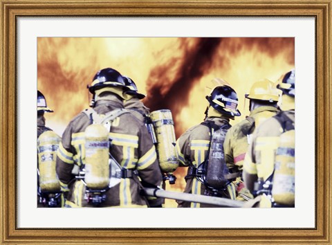 Framed Rear view of a group of firefighters holding water hoses Print