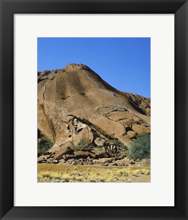 Framed Tourists climbing on a rock, Ayers Rock, Uluru-Kata Tjuta National Park, Australia Print