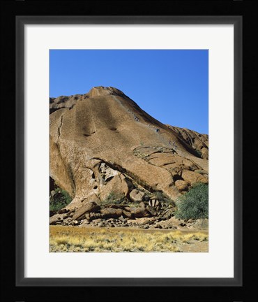 Framed Tourists climbing on a rock, Ayers Rock, Uluru-Kata Tjuta National Park, Australia Print
