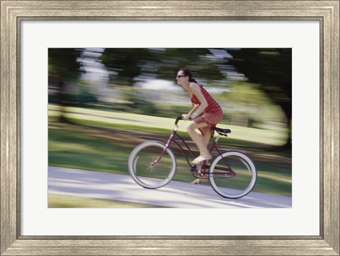 Framed Side profile of a young woman riding a bicycle Print