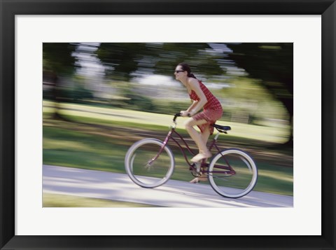 Framed Side profile of a young woman riding a bicycle Print