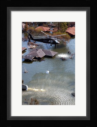 Framed Blackhawk helicopter drops sandbags into an area where the levee broke due to Hurricane Katrina Print