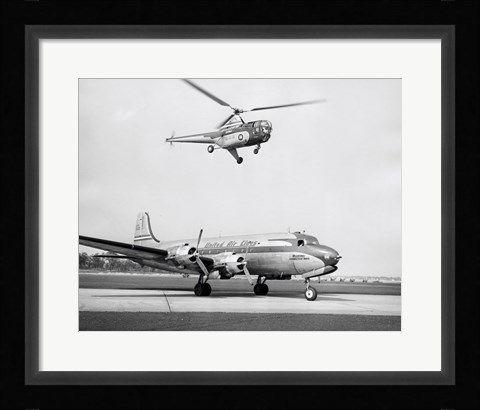 Framed Low angle view of a helicopter in flight and an airplane at an airport, Sikorsky Helicopter, Douglas DC-4 Print
