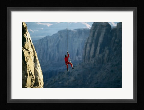 Framed Rear view of a man rappelling down a rock Print