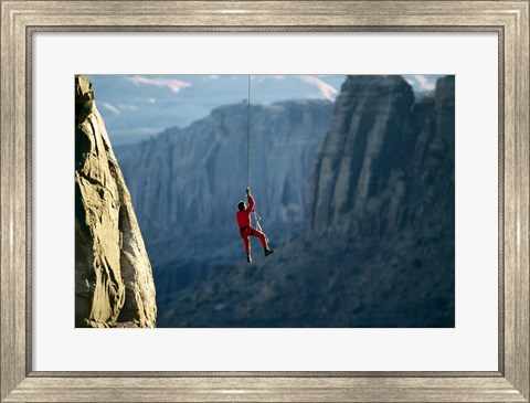 Framed Rear view of a man rappelling down a rock Print