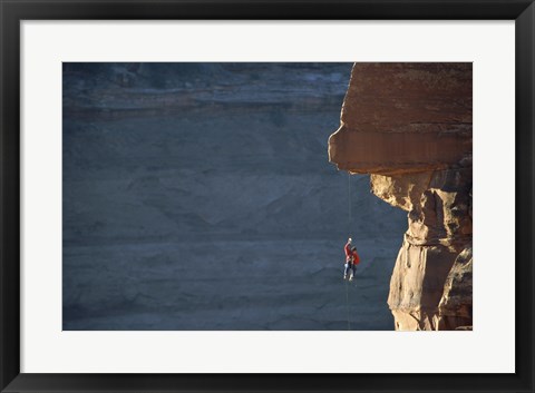 Framed Man hanging from a rope on the edge of a cliff Print