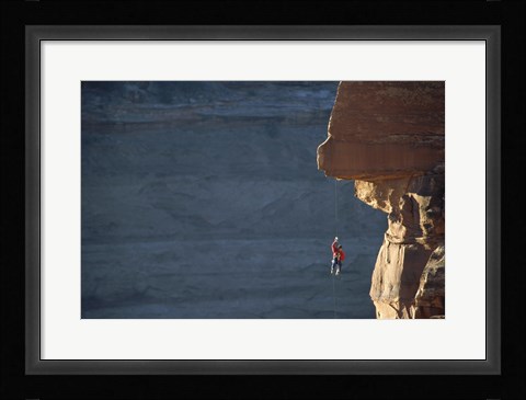 Framed Man hanging from a rope on the edge of a cliff Print
