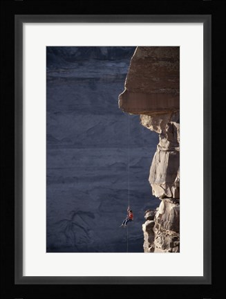 Framed Man hanging from a rope on the edge of a cliff Print
