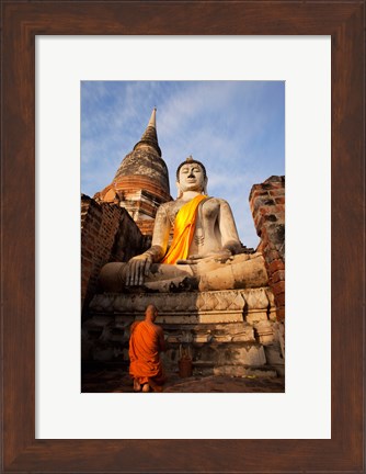 Framed Monk praying in front of a statue of Buddha Print
