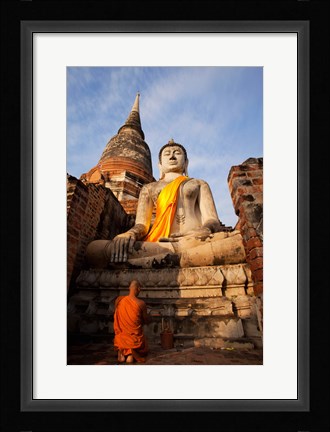 Framed Monk praying in front of a statue of Buddha Print
