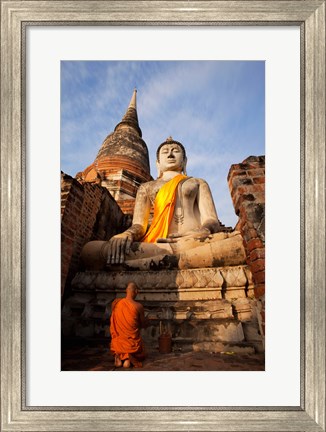 Framed Monk praying in front of a statue of Buddha Print