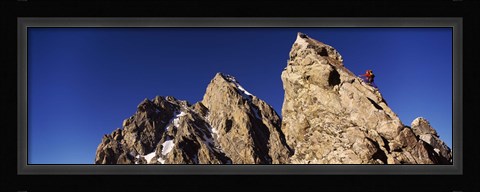 Framed Low angle view of a man climbing up a mountain, Rockchuck Peak, Grand Teton National Park, Wyoming, USA Print