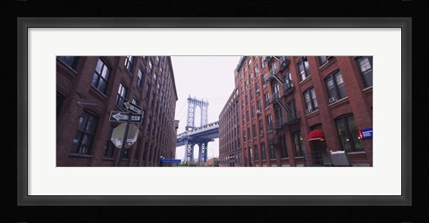 Framed Low angle view of a suspension bridge viewed through buildings, Manhattan Bridge, Brooklyn, New York City, New York State, USA Print