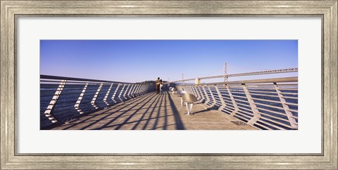 Framed Couple walking on a pier, Bay Bridge, San Francisco, California, USA Print