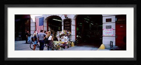 Framed Rear view of three people standing in front of a memorial at a fire station, New York City, New York State, USA Print