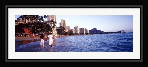 Framed Rear view of a couple wading on the beach, Waikiki Beach, Honolulu, Oahu, Hawaii, USA Print