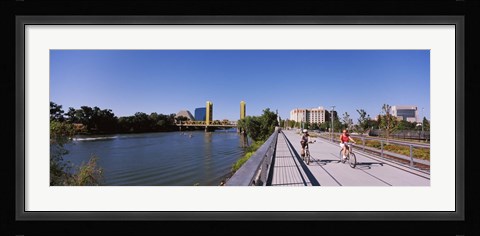 Framed Bicyclists along the Sacramento River with Tower Bridge in background, Sacramento, Sacramento County, California, USA Print